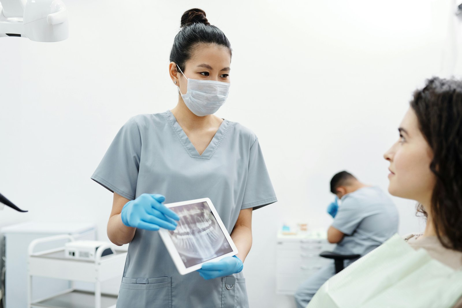 Professional dental team providing care to a patient in modern clinic setting